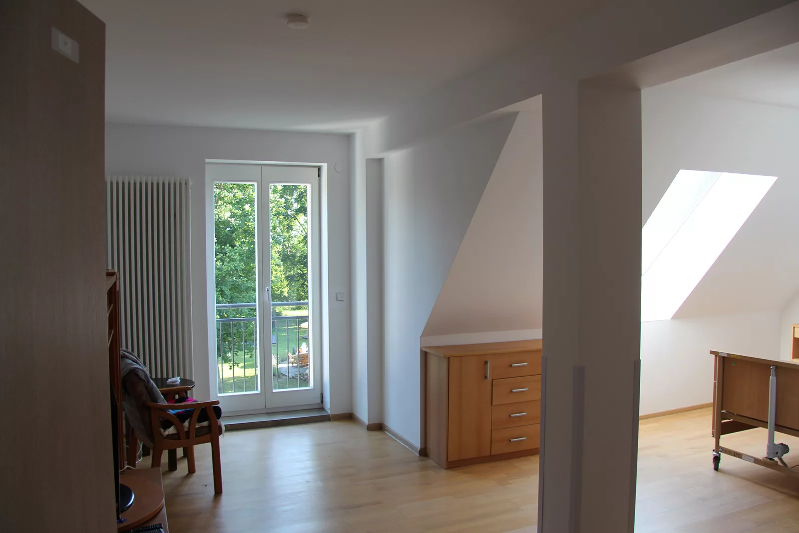 Helles barrierefreies Einzelzimmer mit Pflegebett und Balkonzugang